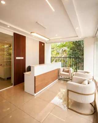 a lobby with a reception desk and two chairs at Nexstay Bayyat Inn in Kozhikode