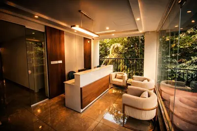 a lobby with two chairs and a large window at Nexstay Bayyat Inn in Kozhikode
