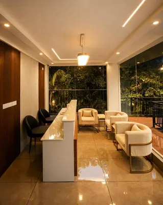a lobby with a bar and chairs and windows at Nexstay Bayyat Inn in Kozhikode