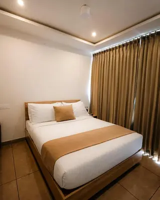 a bedroom with a large bed in front of a window at Nexstay Bayyat Inn in Kozhikode