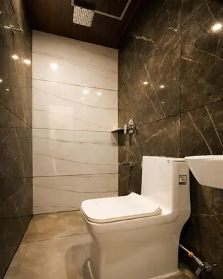 a bathroom with a white toilet and a sink at Nexstay Bayyat Inn in Kozhikode