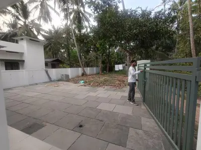 a man standing next to a green fence at Serene riverside retreat in Kozhikode