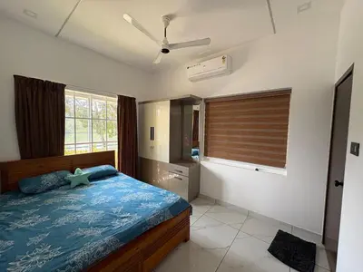 a bedroom with a bed and a ceiling fan at Serene riverside retreat in Kozhikode
