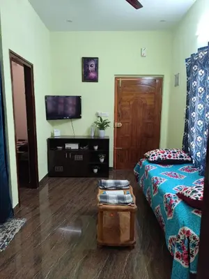 a living room with a couch and a tv at My Sooru - Spacious 2BHK Homely Retreat in Mysore