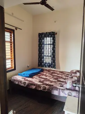 a bedroom with a bed and a window at My Sooru - Spacious 2BHK Homely Retreat in Mysore