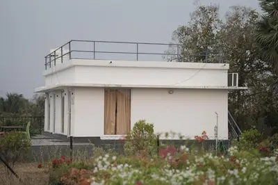 a white house with a balcony on top of it at Bougain Villa Hilltreat in Muthalamada