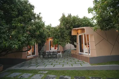 a patio with tables and chairs under trees at Bougain Villa Hilltreat in Muthalamada