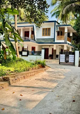 a house with a palm tree in front of it at Sawan Home stay - 2 BHK fully furnished in Kozhikode