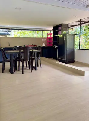 an empty room with tables and chairs and a kitchen at Sawan Home stay - 2 BHK fully furnished in Kozhikode