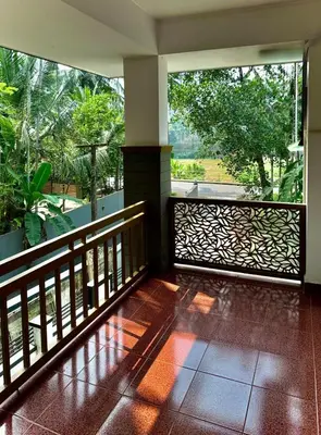 a room with a balcony with a view of trees at Sawan Home stay - 2 BHK fully furnished in Kozhikode