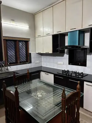 a kitchen with a glass table in the middle at Metro Bliz in Alwaye