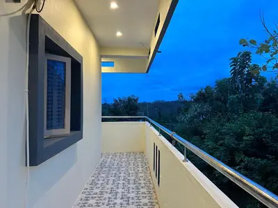 a balcony with a view of the forest at Rivora Retreat in Nanjangūd