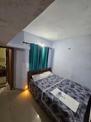 a bedroom with a bed with a blue curtain at Falcon by wayanora in Padinjarathara