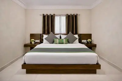 a bedroom with a large bed and a window at Amara Grand in Mysore