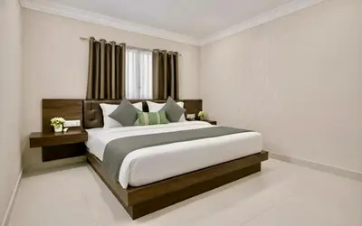a bedroom with a large bed in a room at Amara Grand in Mysore
