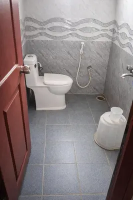 a bathroom with a toilet and a shower at Amara Grand in Mysore