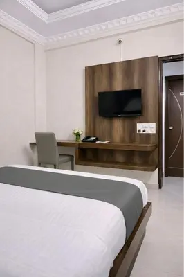 a hotel room with a bed and a tv at Amara Grand in Mysore