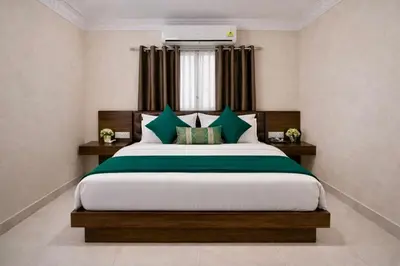 a bedroom with a large bed and a window at Amara Grand in Mysore