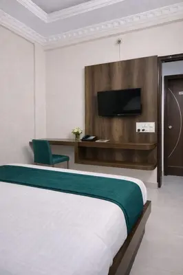 a hotel room with a bed and a tv at Amara Grand in Mysore