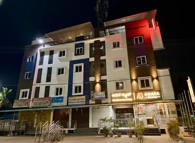 a tall building with lights on it at night at Amara Grand in Mysore