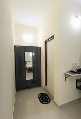 a room with a door and a room with a mirror at Bougain Villa in Madikeri