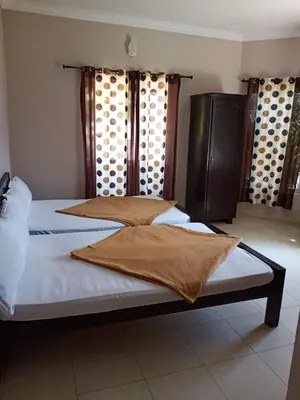 a bed with white sheets and pillows in a room at Mounts shelts in Munnar
