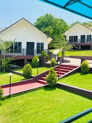 a house with a green yard with a red pathway at WHITE FLOWER mountain resort in Perintalmanna