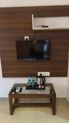 a coffee table in front of a wall with a television at Hemara suites