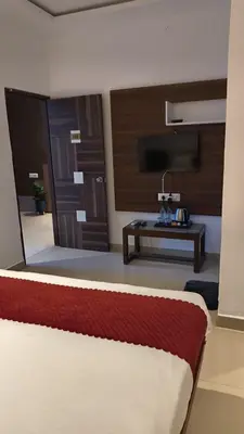 a room with a bed and a living room with a table at Hemara suites