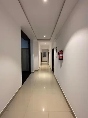 a long hallway with white walls and a long white tile floor at Hemara suites