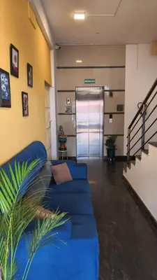 a living room with a blue couch in a building at Hemara suites