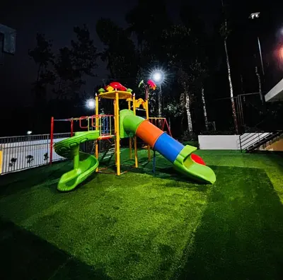 a playground with a slide in a park at night at West wind Resort in Meppādi