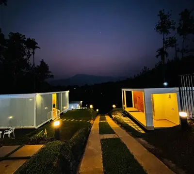 a couple of tiny houses on a street at night at West wind Resort in Meppādi