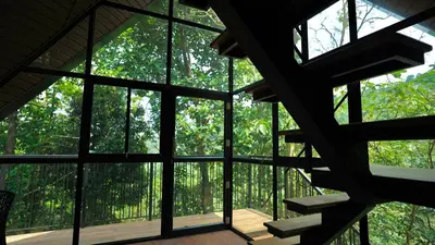 a view from the inside of a building with glass windows at Lostcabins in Vallikavungal