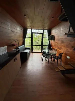 a living room with a couch and a table and chairs at Lostcabins in Vallikavungal