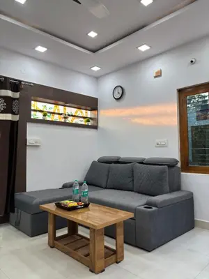 a living room with a couch and a table at Arranyaa retreatt- Girrafe's gallery in Mysore