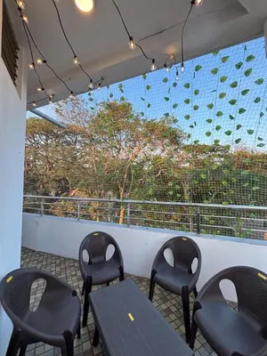 a patio with chairs and a table on a balcony at Arranyaa retreatt- Girrafe's gallery in Mysore
