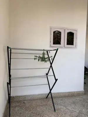 a glass shelf against a white wall with a window at Arranyaa retreatt- Girrafe's gallery in Mysore