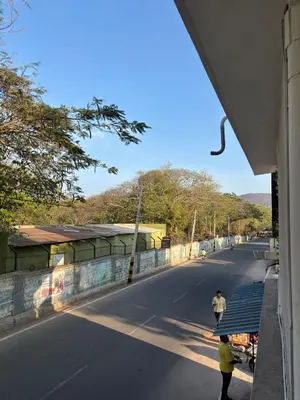 two people walking down a street next to a wall at Arranyaa retreatt- Girrafe's gallery in Mysore