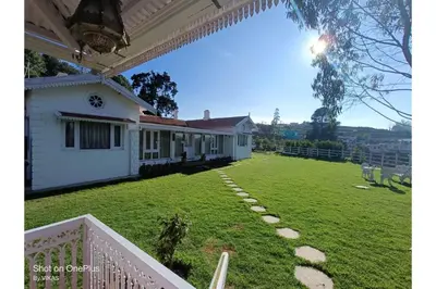a yard of a house with a large lawn at Brooklyn Villa in Ooty