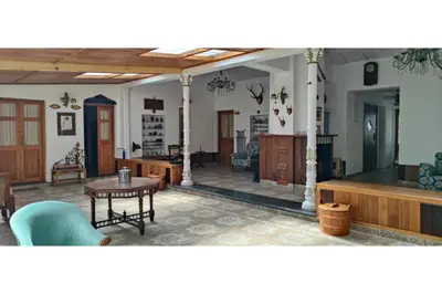 a living room with a table and chairs in it at Brooklyn Villa in Ooty