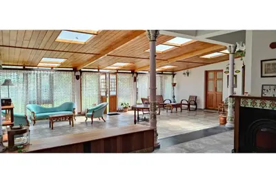a large living room with furniture and a fireplace at Brooklyn Villa in Ooty