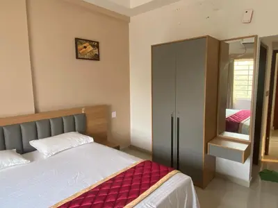 a bedroom with a bed and a wardrobe and a mirror at Nova Alhind Airport Hotel in Nedumbassery