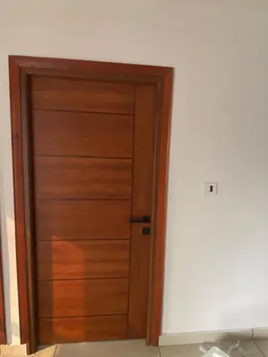a wooden door in the corner of a room at Nova Alhind Airport Hotel in Nedumbassery