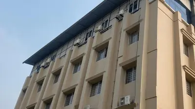a tall tan building with windows on the side of it at Nova Alhind Airport Hotel in Nedumbassery