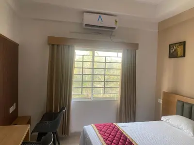 a hotel room with a bed and a window at Nova Alhind Airport Hotel in Nedumbassery