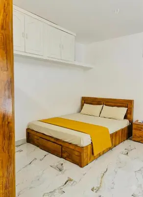 a bedroom with a bed with a yellow blanket at Neelees Retreat in Kaniyāmbetta