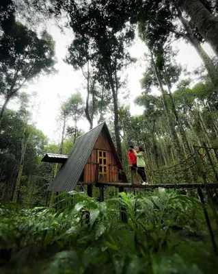 two people standing in front of a small tree house at Wildvibes India in Meppādi
