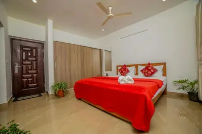 a bedroom with a red bed with a red blanket at Silver Heaven, Kotagiri in Kotagiri