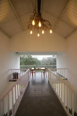 a dining room with a table and a chandelier at Silver Heaven, Kotagiri in Kotagiri